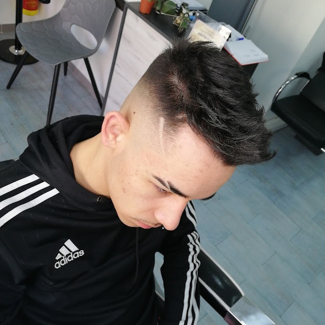 Joven con corte degradado y diseño en el lateral realizado en barbería en Atarfe