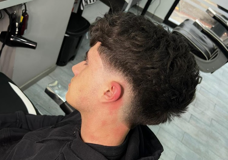 Corte de pelo degradado realizado en joven cliente en barbería en Atarfe